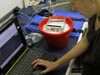 Alison prepares the spectrometer, an instrument that measures the wavelengths in light, to study the absorption and reflectance properties of the fish’s fluorescent lens.