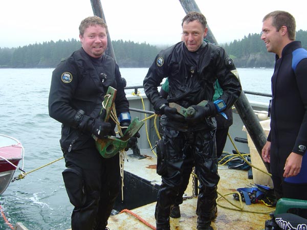 Archaeologists are holding a bronze gudgeon and pintle.