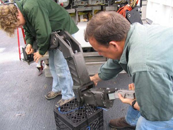 IFE ROV pilot Todd Gregory and IFE chief bosun Mark DeRoche work on the manipulator arm.