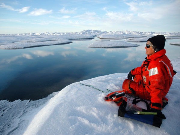 Sue Moore listening intently to real-time sounds captured by an underwater hydrophone