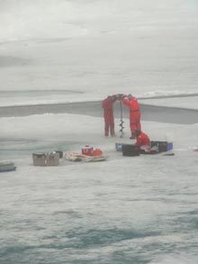 Members of the Sea-Ice team work together to drill a hole in the ice.