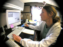 Andrea Quattrini monitors sonar data while the team assesses a potential
            dive site.