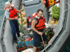 The RV Thompson's small boat approaches the vessel loaded with fresh fruits from port.