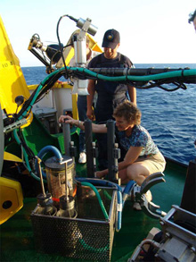 Joanne Goudreau collects water samples from Niskin bottles.