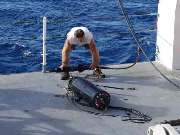 John Stange examines the tow sled control body after retrieval