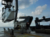 Silhouetted by the morning sun, the ALVIN is gently lifted off the deck of the R/V Atlantis.