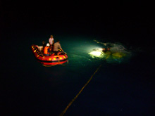 The ROV rescue party watches from the rubber boat as Nick Caloyianis hooks the disabled ROV onto the winch wire so that it can be hoisted onto the deck.