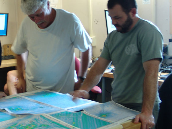 Chief scientist Erik Cordes (right) and geophysicist Bill Shedd review a bathymetric map while discussing what sites to explore next. 