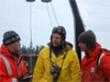 Aleksey Ostrovskiy, center, translates between Chief of Expeditions Vladimir Bakhmutov, left, and graduate student Jared Weems, right.