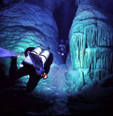 Divers swim between massive submerged stalagmites in Crystal Cave, Bermuda. Such stalactites and stalagmites were formed during glacial periods of lowered sea level when the caves were dry and air-filled.