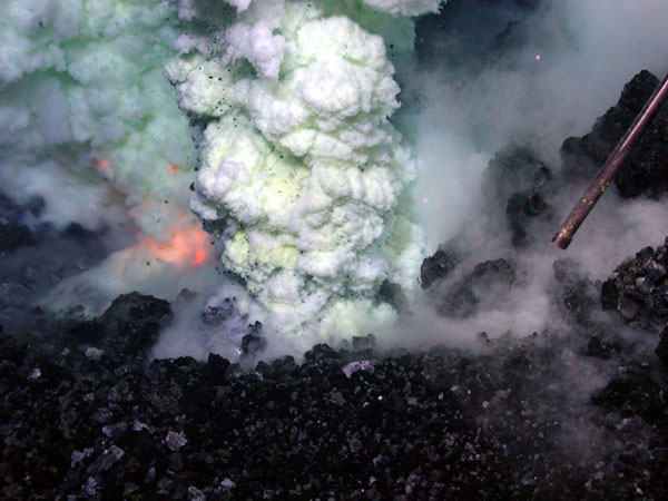 The orange glow of magma is visible on the left of the sulfur-laden plume. This image is approximately six feet across. 