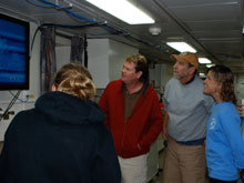 Dr. Cheryl Morrison (right,) and other members of the science party watch with excitement as seafloor imagery appears on the monitor in the main lab.