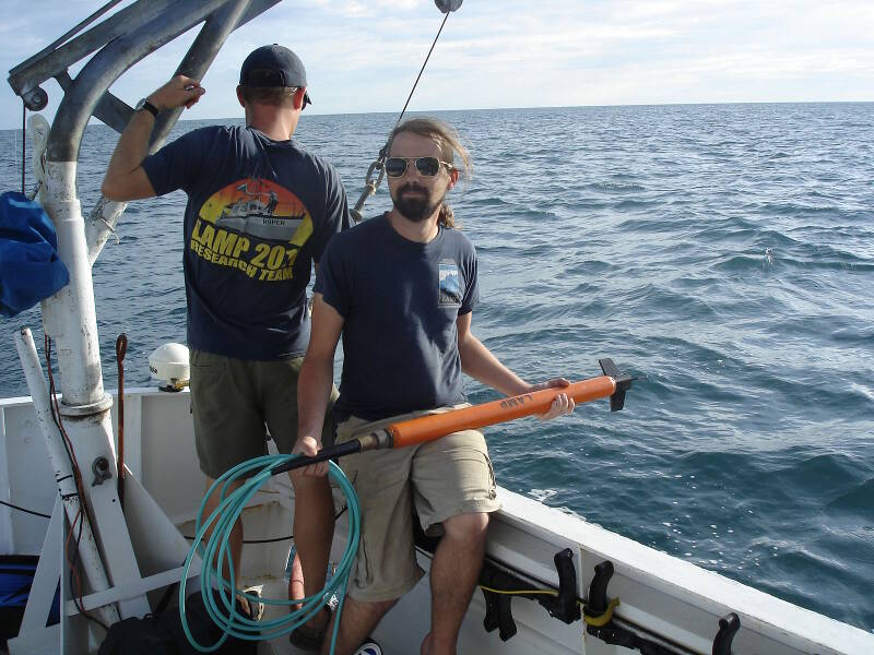 Brian McNamara, LAMP volunteer archaeologist and Flinders University graduate student, standing by with the magnetometer “fish,” waiting to launch it into the sea. The mag head or fish is towed by a length of cable some distance behind the boat. If it is too close to our boat, the steel of the hull or electrical noise from the boat engine could interfere with its magnetic readings.