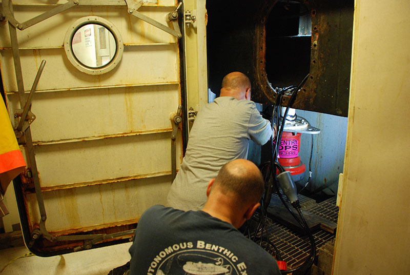 Upon return to Norfolk, Virginia, the Sentry team quickly got to work with the demobilization process to prepare for Sentry’s shipment to its next project. Here, Andy Billings and Mike Jakuba work to remove the AUV transponder from the Pisces centerboard.