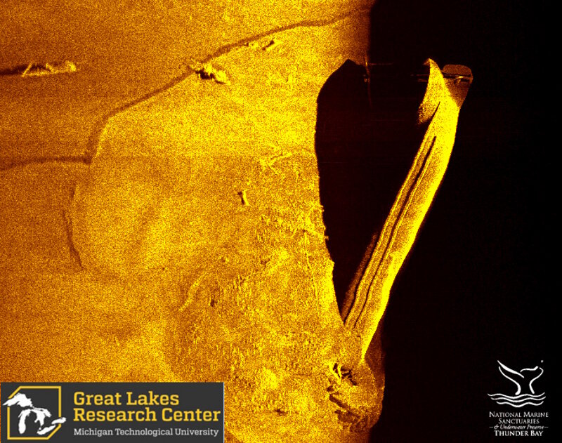 An AUV-acoustic scan of the vessel identified as straight back steamer Choctaw collected in June, 2017. The rounded sides characteristic of this vessel can be seen via the lack of defined edge on the upper (left) side as it extends into the lake bottom. Its unique, pointed stern is also visible. Almost half of Choctaw, however, appears buried in the lake bottom.