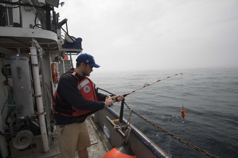 University of Delaware sonar technician Peter Barron prepares to lower a device that will measure the speed of sound throughout the entire water column. These sound velocity profiles were collected once every four hours during the entire survey.