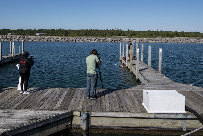 MTU’s Jamey Anderson and Chris Pinnow demonstrate the launch, operation, and recovery of the Iver3 AUV to a film crew from Alpena’s WBKB TV network. This demonstration took place at Michigan’s Presque Isle State Marina.