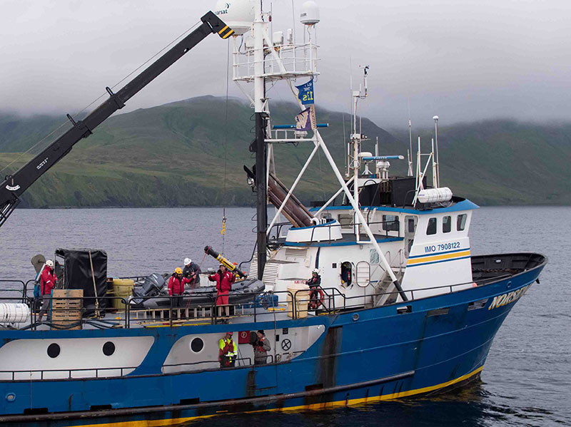 Deploying one of the autonomous underwater vehicles for surveying Kiska Harbor off the side of the Norseman II.