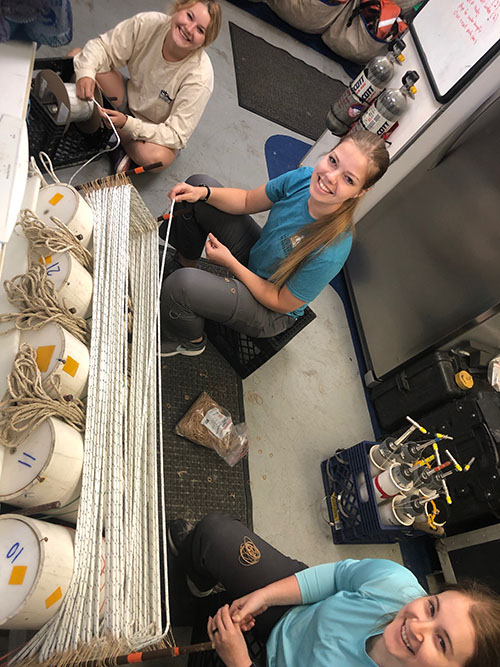 Students Rachel Mugge, Taylor Lee, and Rachel Pugh preparing the microbial recruitment experiments for deployment.