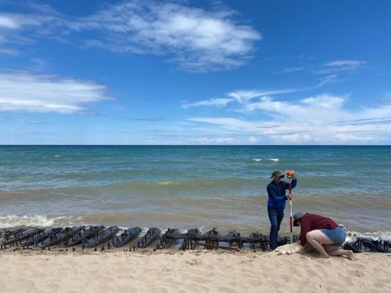 Underwater Archaeology Field School students using a total data station to precisely map ship wreckage during the Discovering the Submerged Prehistory of the Alpena-Amberley Ridge in Central Lake Huron expedition.