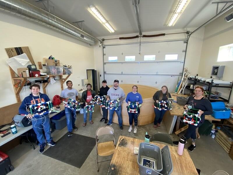 Undergraduate students from Texas at Thunder Bay National Marine Sanctuary with the remotely operated vehicles that they built during the Underwater Archaeology Field School hosted as part of the Discovering the Submerged Prehistory of the Alpena-Amberley Ridge in Central Lake Huron expedition.