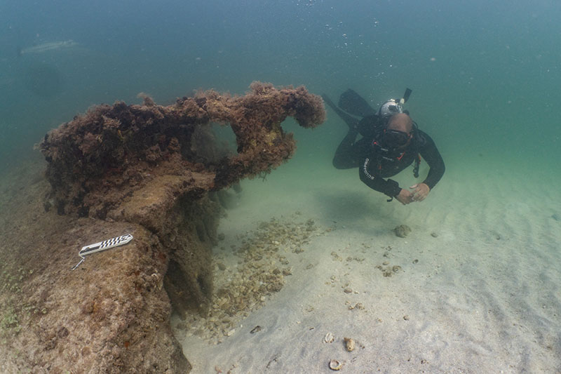 UM student Ryan Fochs examining a diagnostic hawse pipe on site NOAA1. Image courtesy of NOAA and UM-RSMAS, Quicksands Archaeological Survey.