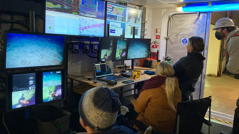 The Marine Applied Research and Exploration (MARE) remotely operated vehicle operator (far left) flies the equipment at depth while the Student Explorations Around Southern California: Acoustics, Paleolandscapes, and Environments at Sea (SEASCAPES) project science team and ship crew monitor the video output.