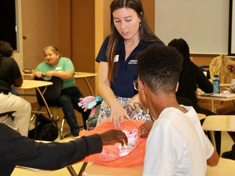 After the expedition, during a visit to the Boys & Girls Clubs of St. Lucie County, Courtney Brooks returns decorated and shrunken cups to the teens who created them.