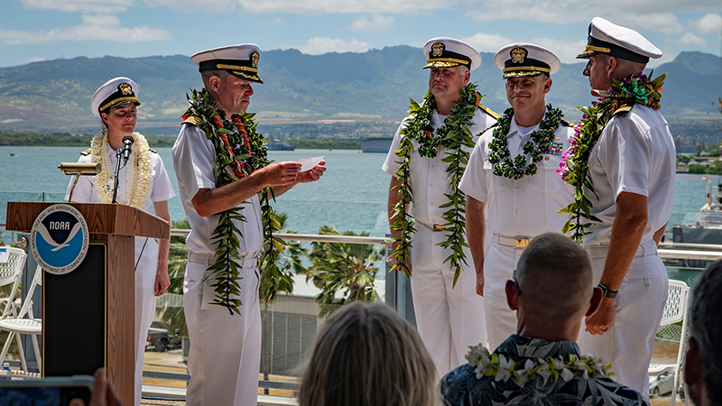 Outgoing commanding officer of NOAA Ship Okeanos Explorer, Captain Colin Little, addresses incoming commanding officer Commander Tony Perry III during a change of command ceremony in Honolulu, Hawaiʻi.