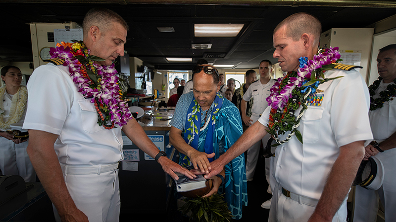 Incoming NOAA Ship Okeanos Explorer commanding officer Commander Tony Perry III (left) and outgoing commanding officer Captain Colin Little (right) participate in a traditional Hawaiian blessing on the bridge of the ship.