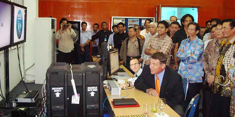 During a visit to the Jakarta Exploration Command Center, U.S. Ambassador Cameron Hume speaks to U.S. and Indonesian representatives onboard NOAA Ship Okeanos Explorer. Minister Fadel of Indonesia’s Ministry of Marine Affairs and Fisheries stands behind him.