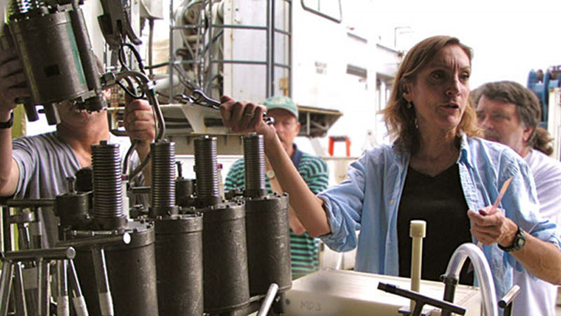 Dr. Karen Von Damm makes adjustments to the sampling basket on the DSV Alvin, in preparation for a dive following a 2005-2006 eruption on the East Pacific Rise spreading center. Dr. Von Damm is remembered for her seminal research on the processes controlling hydrothermal fluid chemistry, along with her commitment to teaching and advising young scientists.