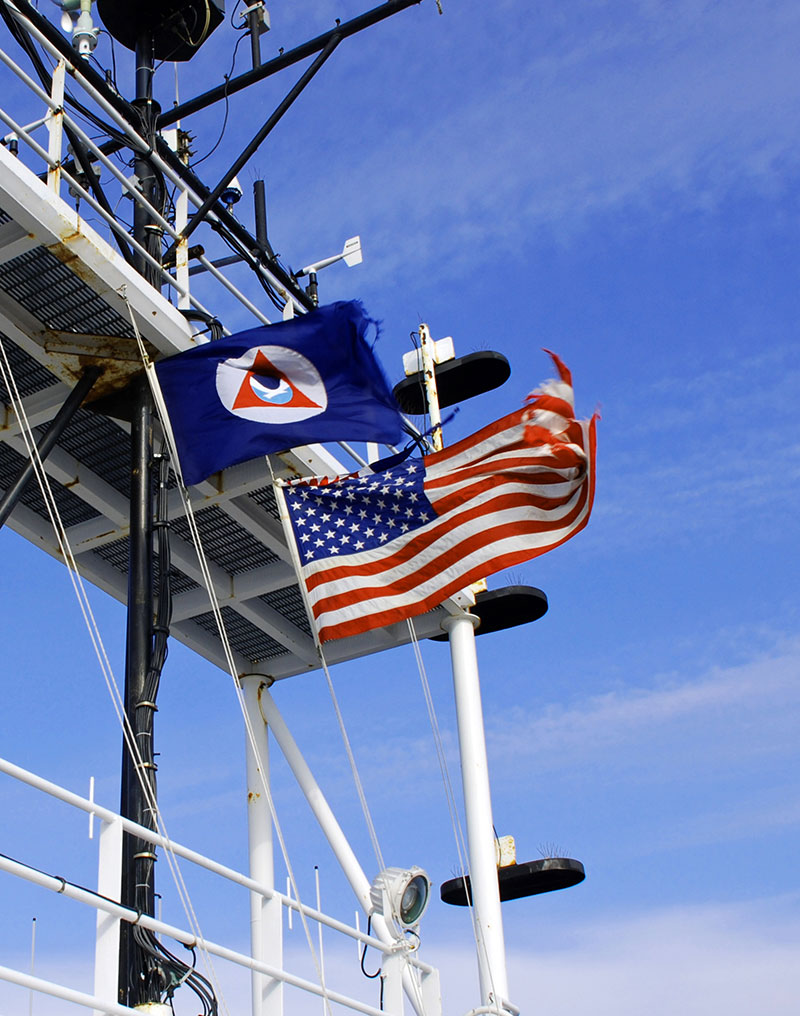 The NOAA and American flags fly above NOAA Ship Okeanos Explorer.