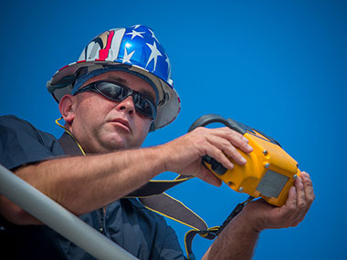 Tyler Sheff, Chief Boatswain, operates ROV Deep Discoverer’s crane with a wireless control.