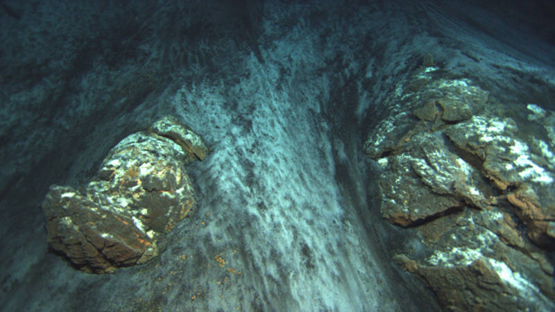 A contact is a sharp boundary between two geologic units. Here we see a clear boundary where sand has slid down to partially cover lava flows on a steep slope.