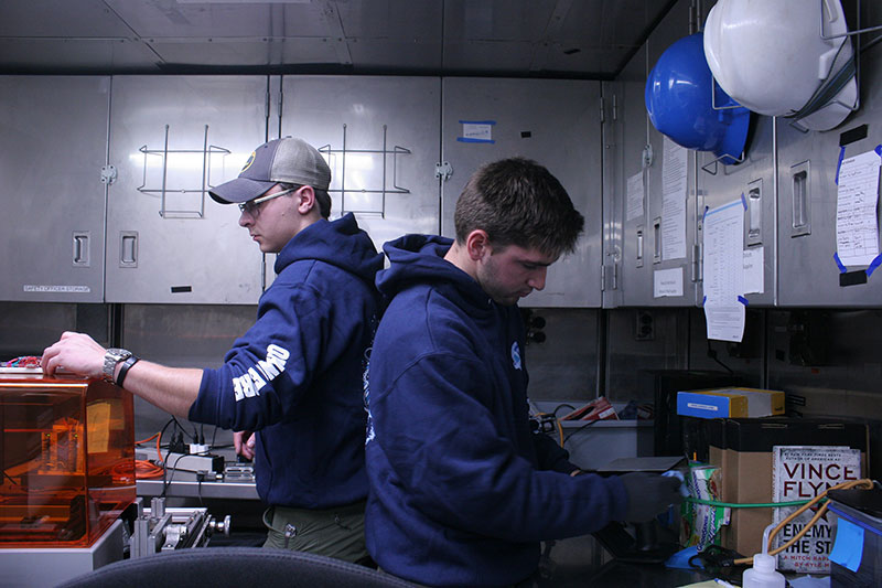 Sean and Grady working seamlessly to switch out a completed print on the 3D printer and start a new one.